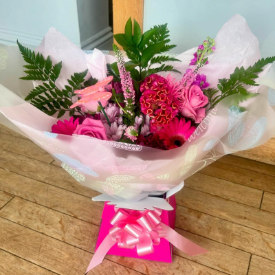 Petal Paradise - A lively bouquet featuring a bright mix of vibrant seasonal blooms. Complemented by lush green foliage and presented in a beautiful packaging, this arrangement is perfect for adding a pop of colour to any occasion